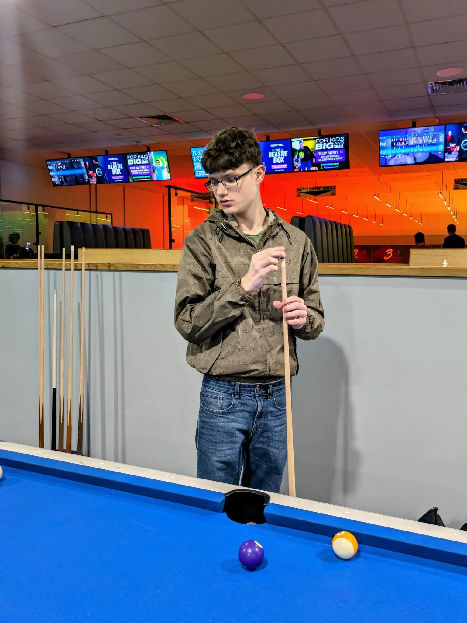 Preston Arnold at a pool table chalking his cue